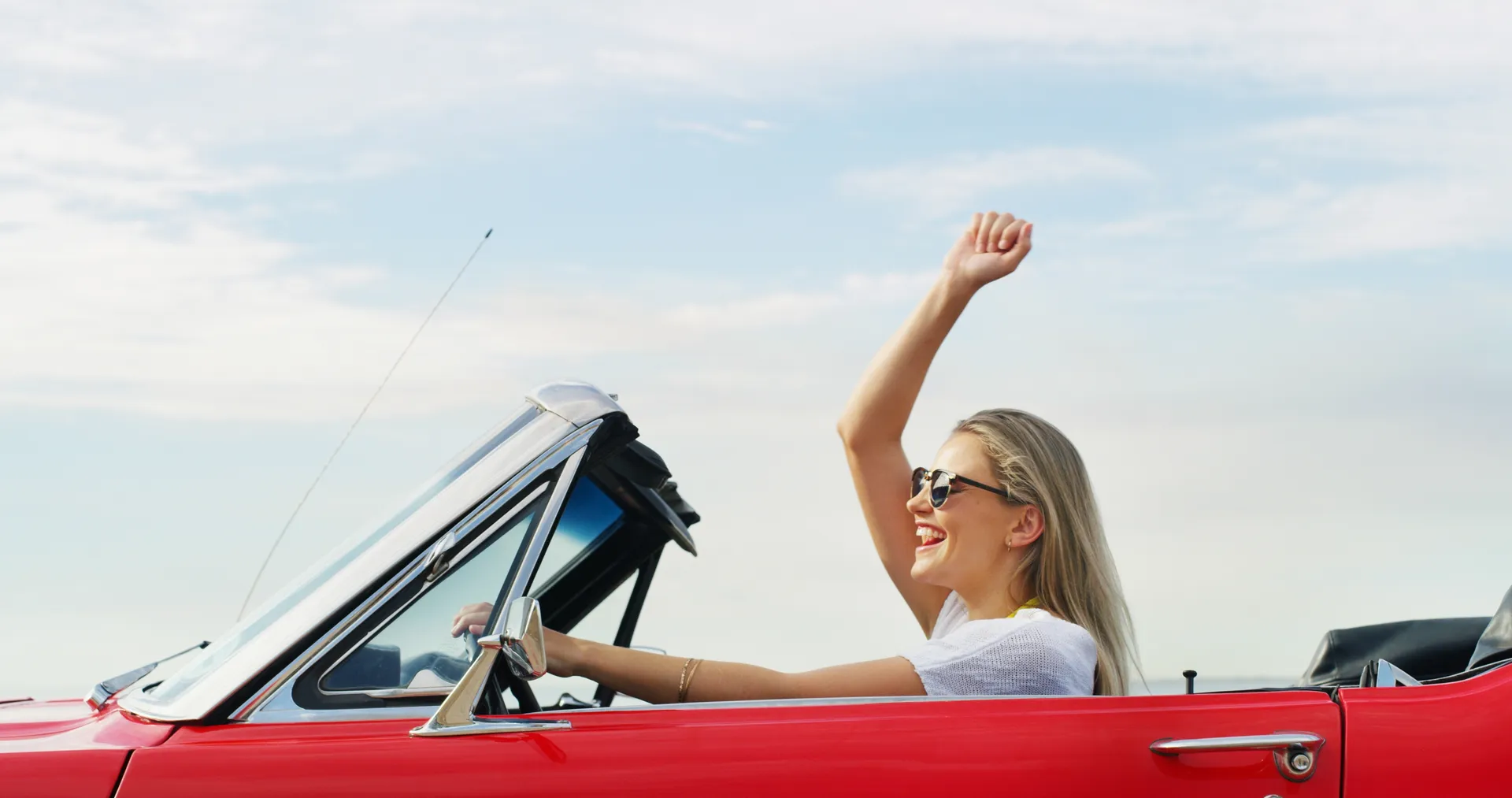 Happy woman smiling while driving clean car from Downtowner Car Wash Fort Myers